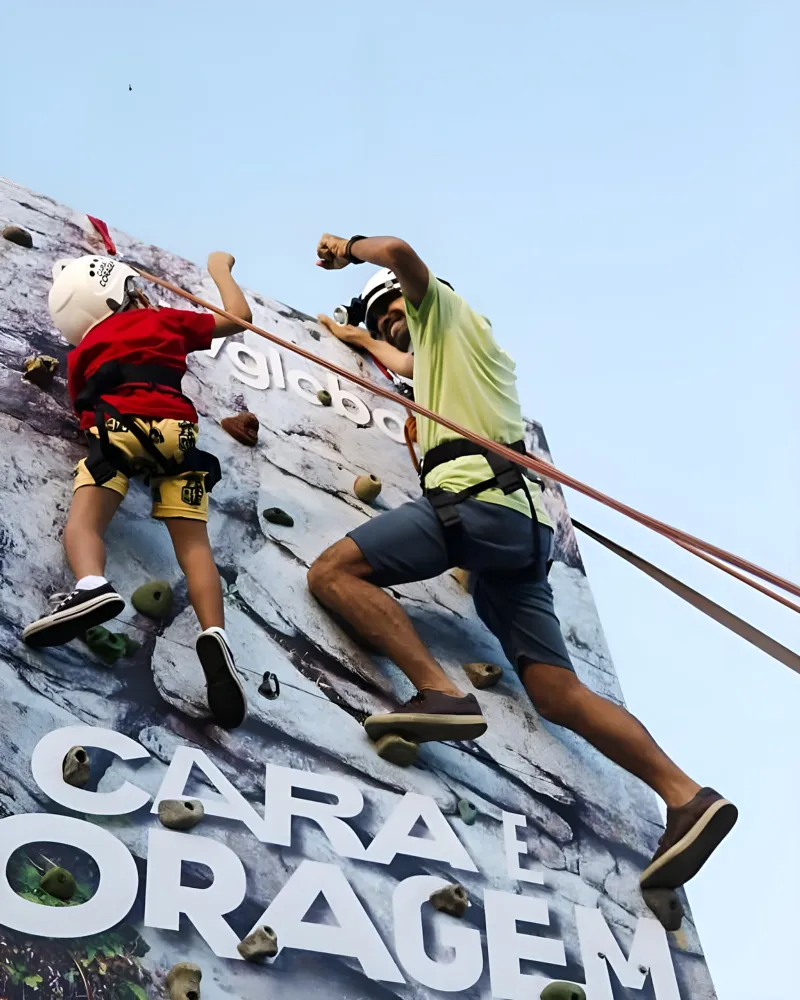 Criança e adulto escalando lado a lado na parede personalizada — Tribo da Trilha PE